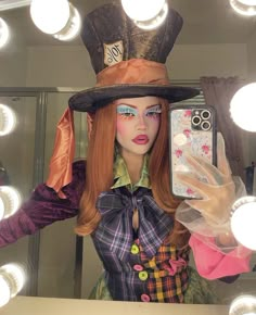 a mannequin wearing a top hat and holding a cell phone in front of a mirror