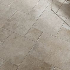 a white chair sitting on top of a floor next to a tile flooring pattern