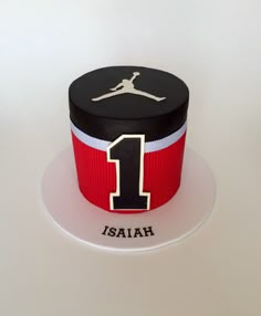 a cake that has the number 1 on it and is decorated with a basketball jersey