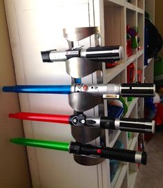 a bunch of star wars lightsticks are hanging from a rack in a room