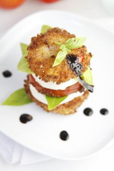 a white plate topped with an appetizer on top of lettuce and tomatoes