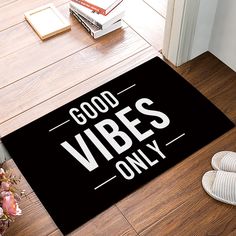 a door mat that says, good vibes only on the floor next to a pair of slippers