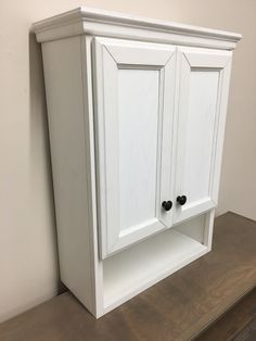 a white cabinet sitting on top of a wooden counter