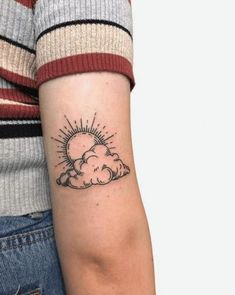 a woman with a small sun and cloud tattoo on her arm