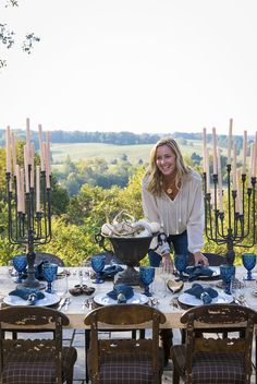 a woman standing at a table with blue dishes on it