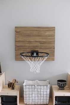 a basketball hoop mounted to the side of a wall above a basket in a living room