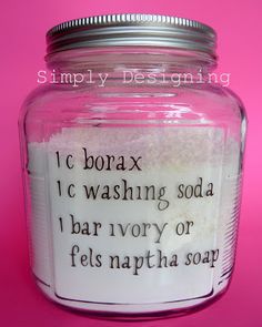 a jar filled with lots of white stuff on top of a pink table next to a wall