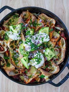 a skillet filled with food on top of a wooden table