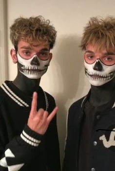 two young men with painted face make up posing for the camera