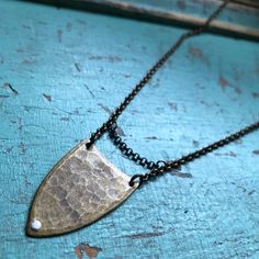 "This hammered, rustic spear is modernized by a sterling rivet and a sterling chain detail. Perfect for the warrior in us all and a great unisex piece. It makes a great layering necklace. It also comes in sterling. It hangs on an oxidized, adjustable 16-18\" brass chain. 2nd photo shows this piece layered with the triple spear necklace in mixed metals." Burlington Vt, Hammered Brass, Find Objects, Hammered Silver, Brass Chain, Mixed Metals, Layered Necklaces, Dog Tag Necklace, Silver Chain