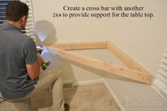 a man is working on the wall in his room with some wood framing around it