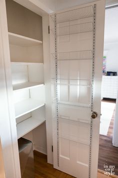 there is a white closet with shelves in the corner and a door to another room