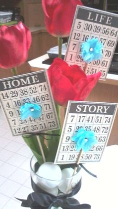 three flowers are in a vase with a calendar on the table next to each other