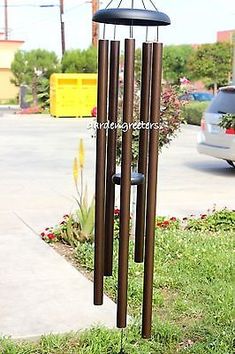 a wind chime in the grass next to a parking lot