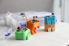 three small plastic toy animals sitting on top of a table next to other toys and containers