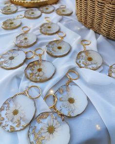 a table topped with lots of white and gold plates covered in daisies next to a wicker basket