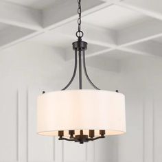 a chandelier hanging from the ceiling in a room with white walls and wood paneling