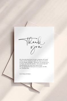 a thank card with the word thank you written in cursive ink on it