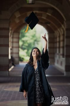 a woman in graduation cap and gown throwing her hat into the air with one hand