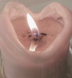 a pink heart shaped candle sitting on top of a table