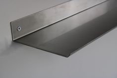 a stainless steel shelf mounted to the side of a wall with a button on it