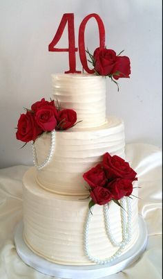 a white wedding cake with red roses on top and the number forty written on it