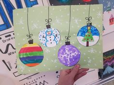 someone is holding up some christmas cards with snowmen and baubles on them