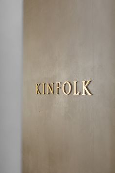 a sign that reads kinfolk on the side of a wall