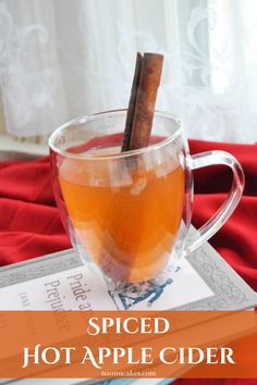 spiced hot apple cider in a glass mug with cinnamon stick sticking out of it