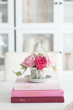 pink roses in a teacup on top of two books