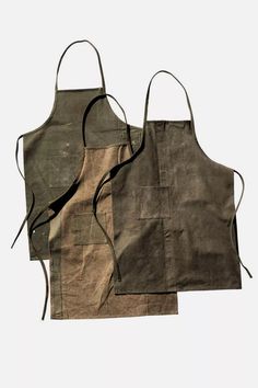 two aprons with different colors and designs on the front, one in grey and one in brown