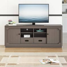 a flat screen tv sitting on top of a wooden entertainment center in a living room