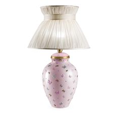 a pink and white vase with a lamp on the top is sitting in front of a white background