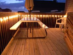 a table and chairs on a deck with lights