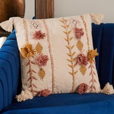 a blue chair with a decorative pillow on it's back and tassels around the edges