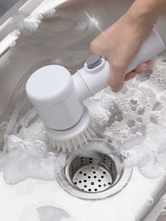 a person is washing their hands in the sink with a brush and soap dispenser