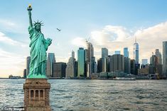 the statue of liberty in new york city is shown from across the water with skyscrapers behind it