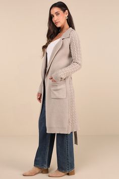 Spend the chilly season cozied up in the Lulus Cozy Effect Taupe Cable Knit Duster Cardigan! Soft and chunky knit shapes this ultra-comfy sweater that has long, cable-knit sleeves and a matching pattern of cable knit at the back. Collared neckline has notched lapels, atop a longline, duster-style bodice with two functional pockets, belt loops, and a tying sash belt. Fit: This garment fits true to size. Length: Mid-calf length. Size medium measures 40.25" from shoulder to hem. Bust: Great for any Fall Cable Knit Beige Sweater Coat, Cable Knit Outerwear For Cold Weather, Cable Knit Winter Outerwear For Cold Weather, Cable Knit Winter Outerwear, Cozy Knitted Sweater Coat For Layering, Cozy Beige Knit Sweater Coat, Beige Cable Knit Sweater For Cold Weather, Cable Knit Outerwear For Winter, Beige Cable Knit Sweater Coat With Long Sleeves