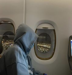 a person sitting in an airplane looking out the window at the city lights from inside