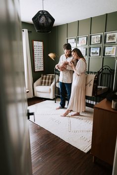 a man and woman standing next to each other in front of a baby crib