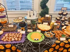 a table filled with halloween treats and desserts