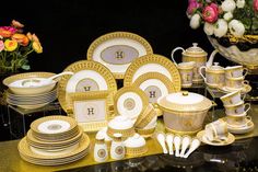 a table topped with lots of gold and white dishes