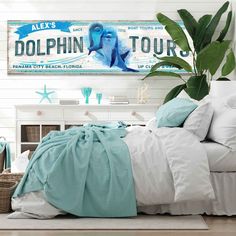 there is a bed with white sheets and blue comforter on the floor next to a sign that says dolphin tours