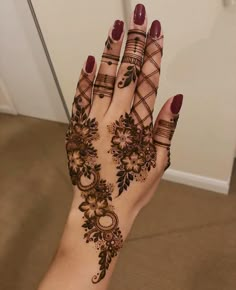 a woman's hand with hennap and flowers on the palm, holding it up