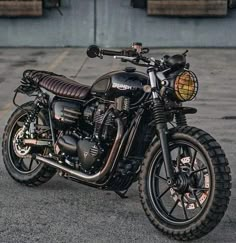 a black motorcycle parked on top of a parking lot