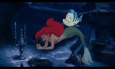 the little mermaid from disney's the little mermaid is laying on her stomach and looking down