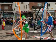 some people are walking in the street with flags and kites on display for everyone to see