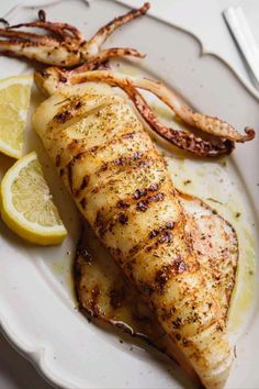 a white plate topped with chicken and lemon slices