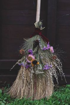 a broom with flowers on it sitting in the grass