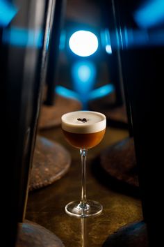 a drink sitting on top of a table next to a mirror